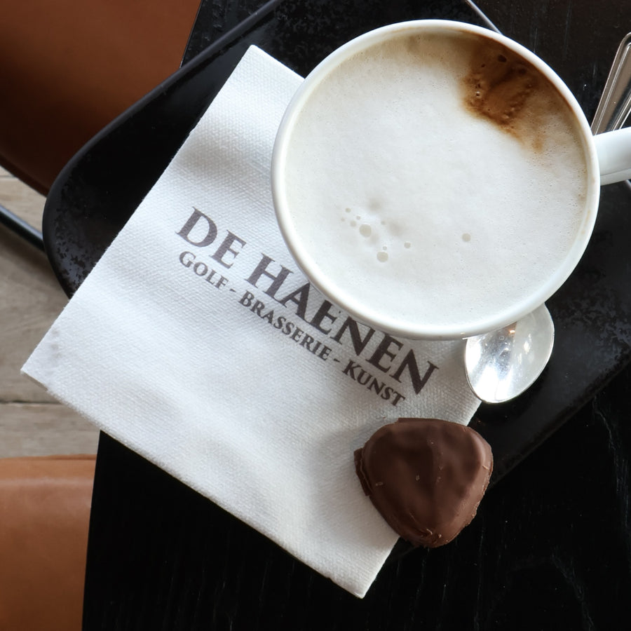Bedrukt servet van De Haenen bij een cappuccino